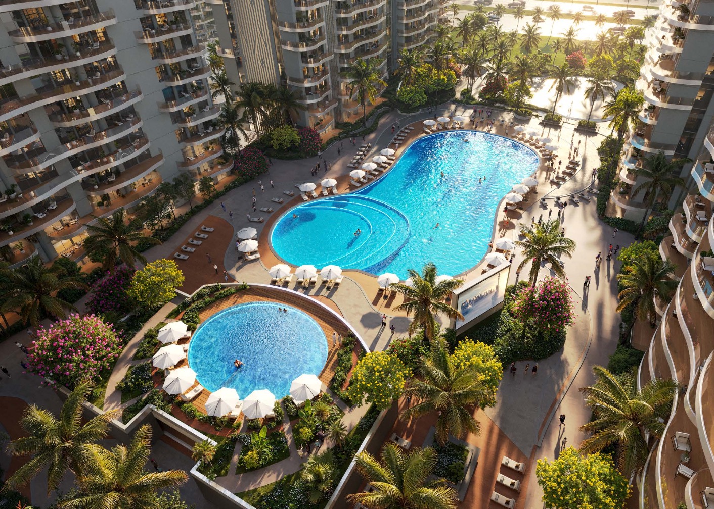 Aerial of curved swimming pools edged with palms and sun loungers