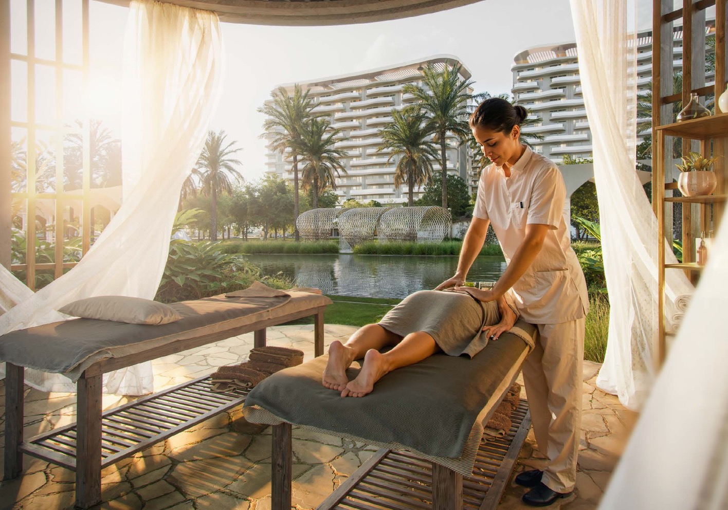 Massage beds under draped cabana beside the water