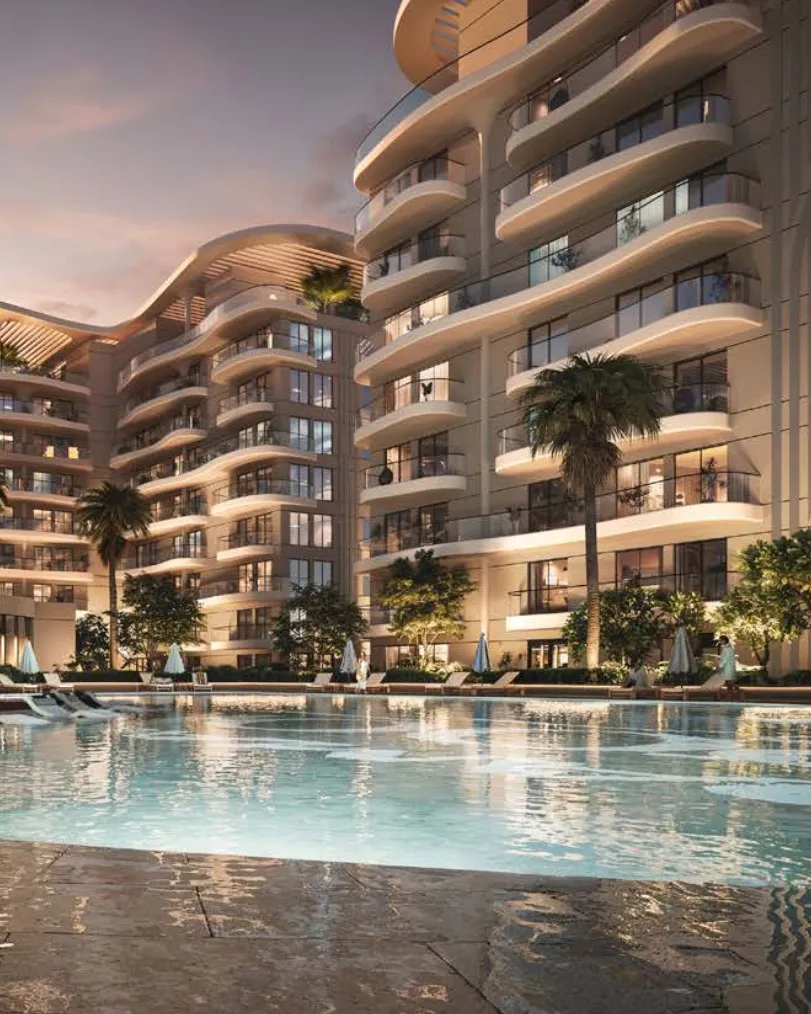 Curved balconies of Sorrento towers above a pool at dusk